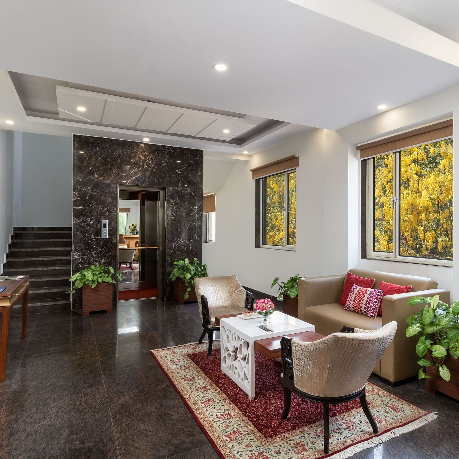 A spacious hotel lobby with comfortable seating, elegant decor, and plenty of natural light | Inde Hotel Cyber City