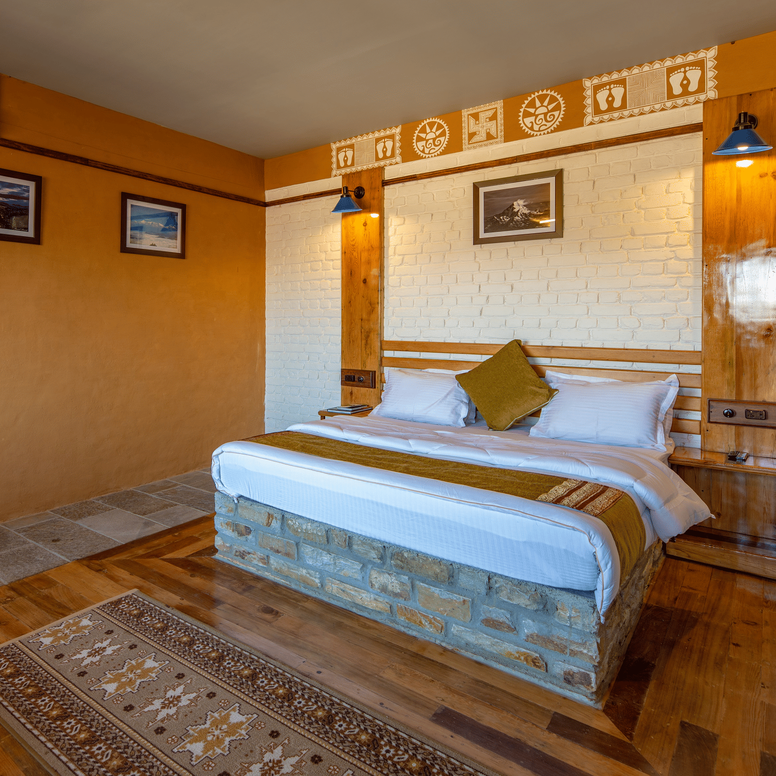 Warm bedroom with wooden flooring, white brickwork, and traditional art above the headboard. - Blusalzz Homes The Himalayan Bungalow, Almora