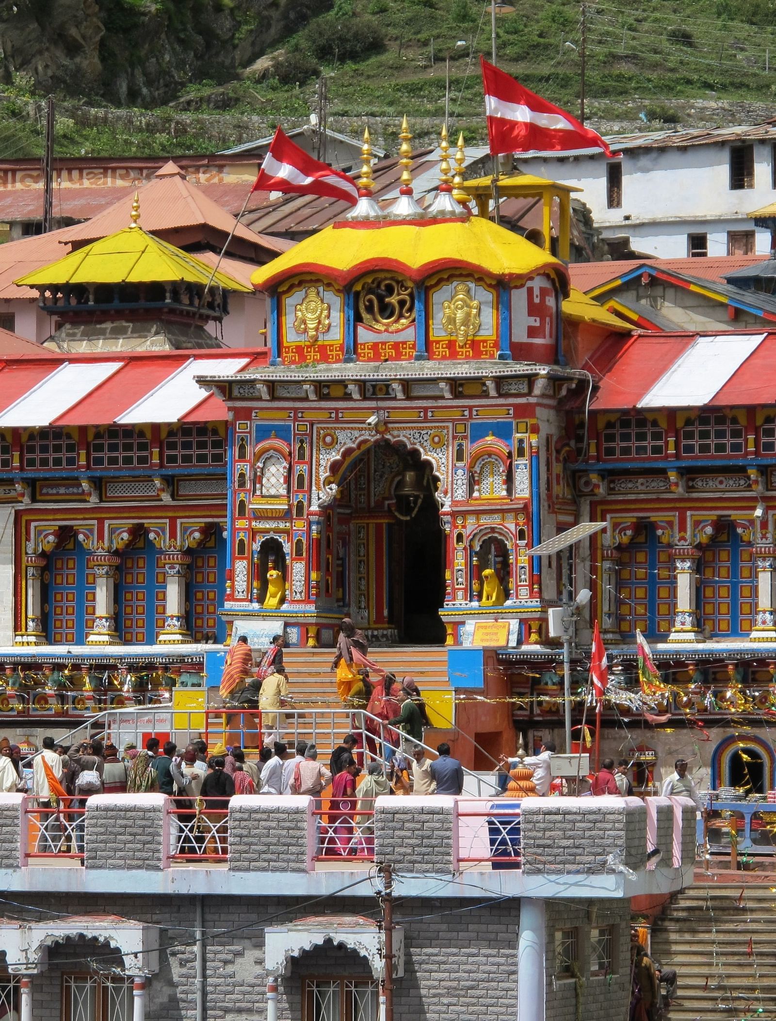 image of a temple with colourful exterior with red and white coloured flags hoisted