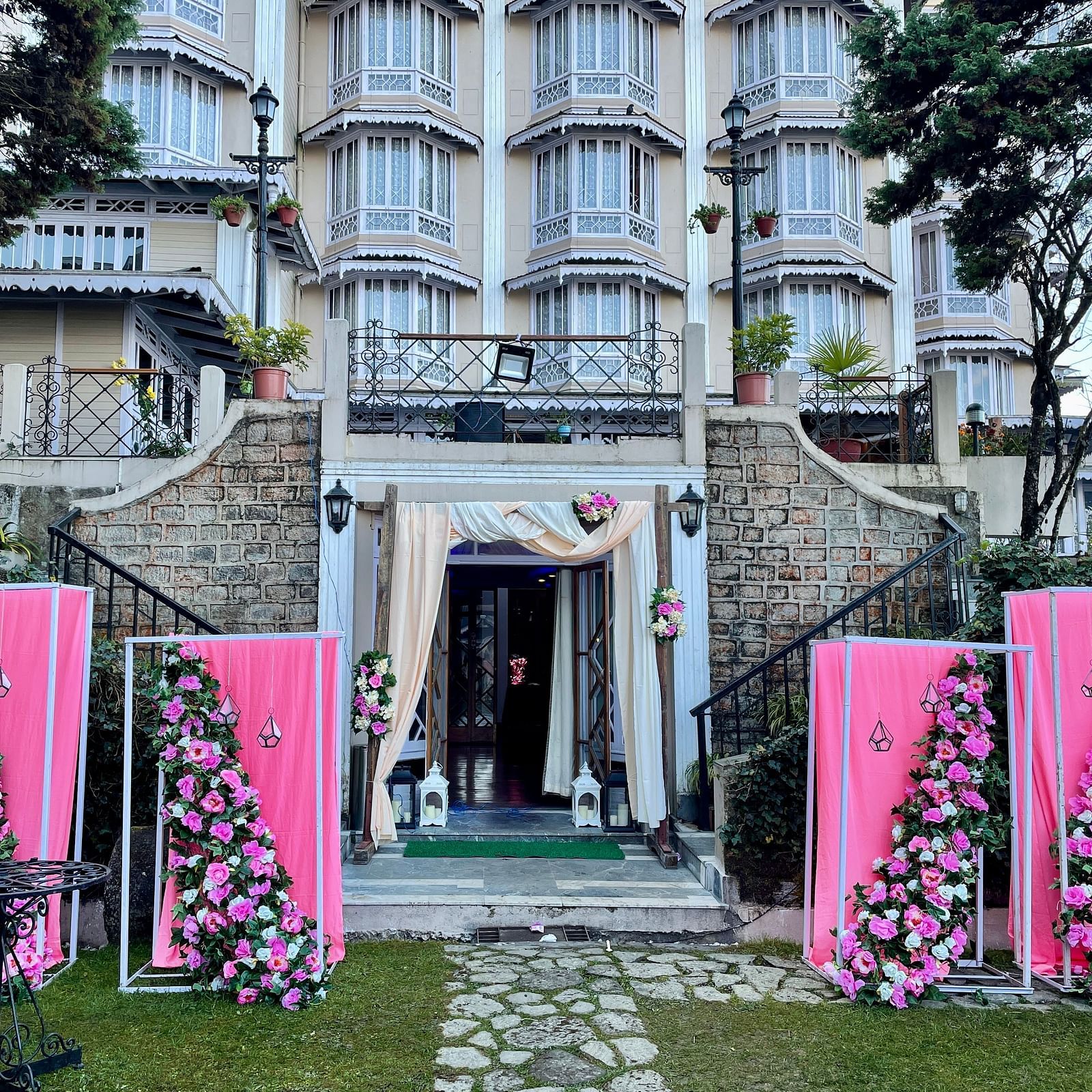 Wedding entrance decor at Cedar Inn, Darjeeling, showcasing the lawn area with floral arrangements and the property's charming exterior.