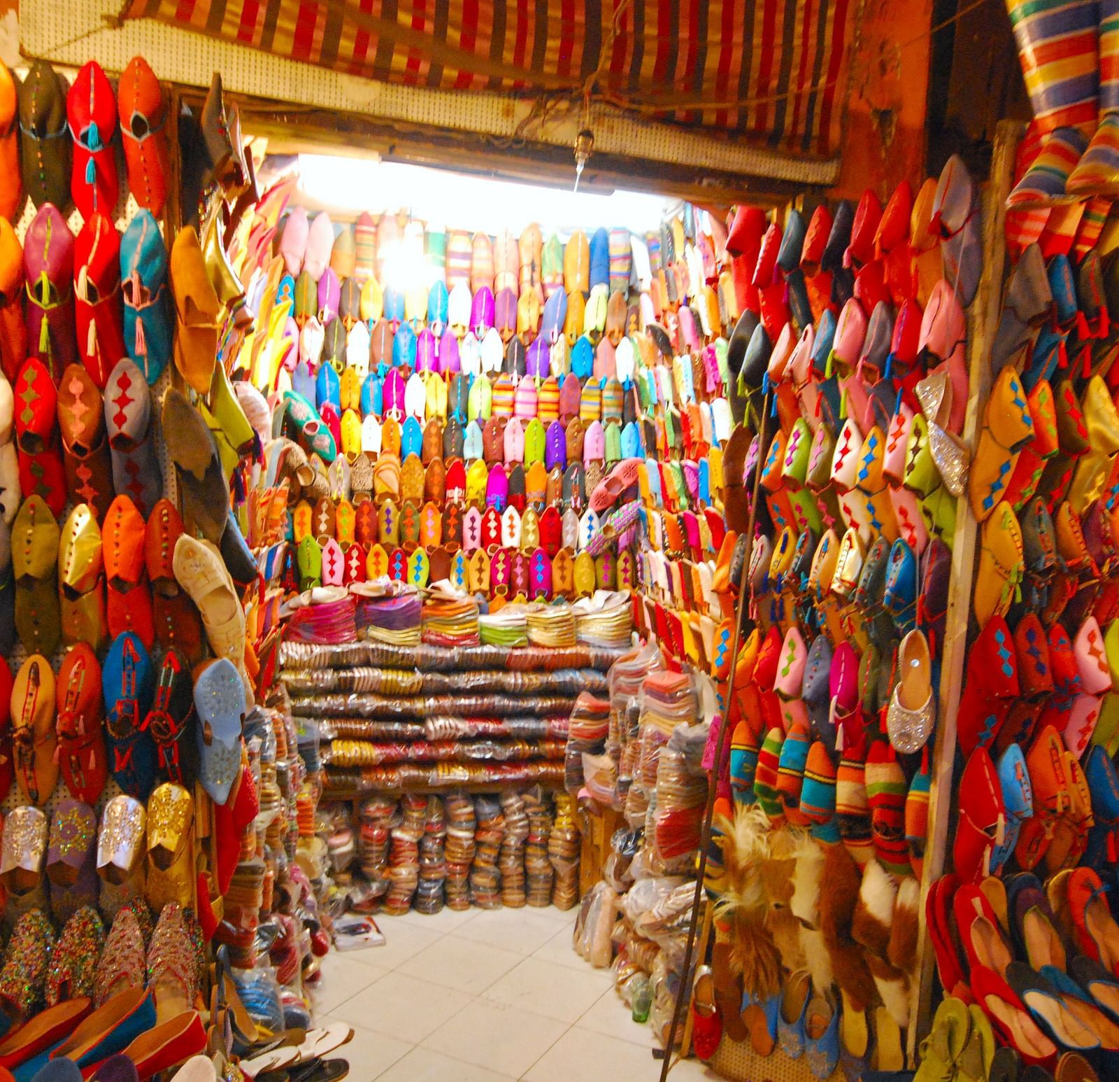 A shoe shop interior featuring colorful shoes displayed on the walls, creating a vibrant atmosphere