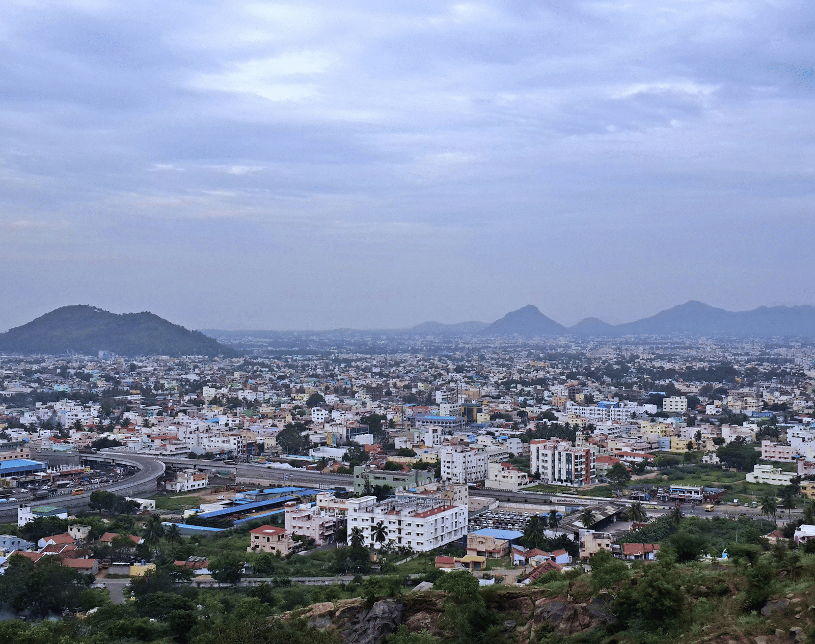 An overview of the city of Salem in Tamil Nadu with many buildings and hills in view.