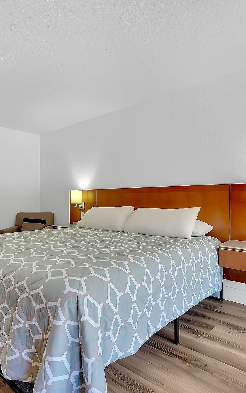 A view of a room at Amador Hotel with a double bed and side lamps.