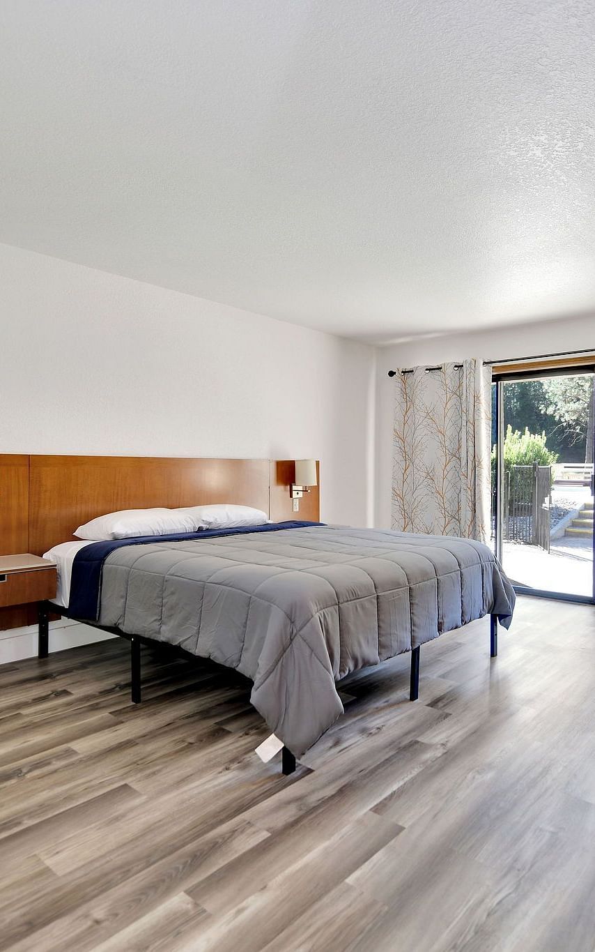 A view of a room at Amador Hotel with a double bed and a sofa chair.