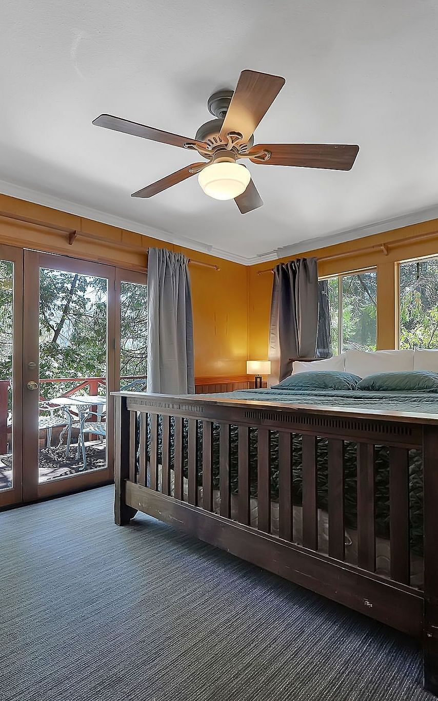 A view of a room at Narrow Gauge Inn with a double bed and sliding doors opening to a balcony.