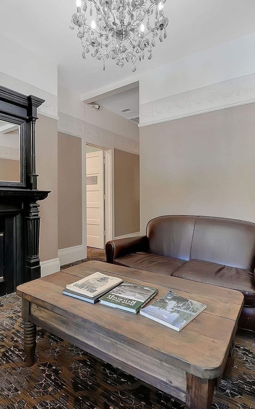 Living room area of a suite at The Groveland Hotel with sofa seating and a coffee table.