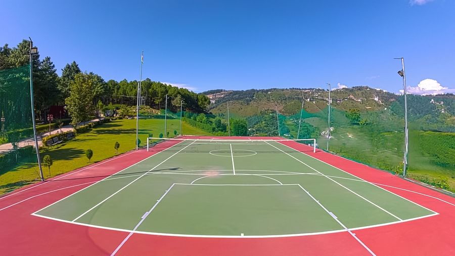 Multi-sport court with basketball hoops and tennis lines set against stunning mountain backdrop at The Manor Wellness & Sports Hotel