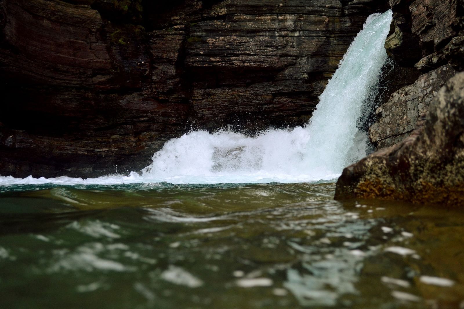 a close up shot of rapid flow of water at a waterfall
