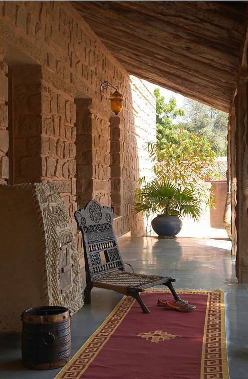 An image of a corridor with a chair and rug at the MANVAR Resort & Desert Camp