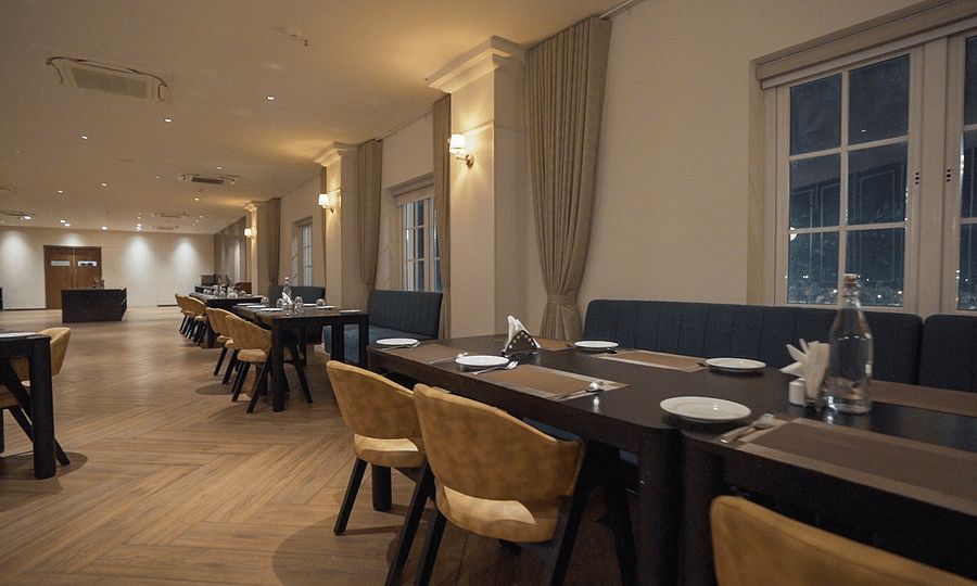 alt-text Side view shot of the restaurant at Pride Resort, Rajkot with navy blue coloured walls giving an elegant look