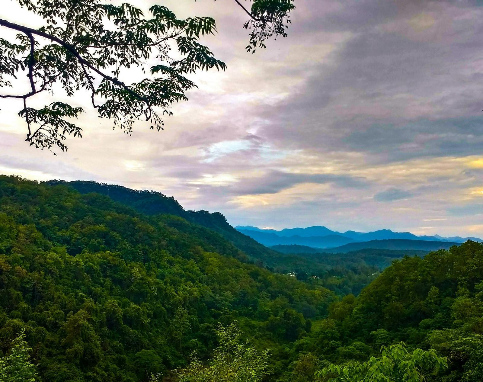 a mesmerising landscape of dehradun with a beautiful sky with clouds in the background