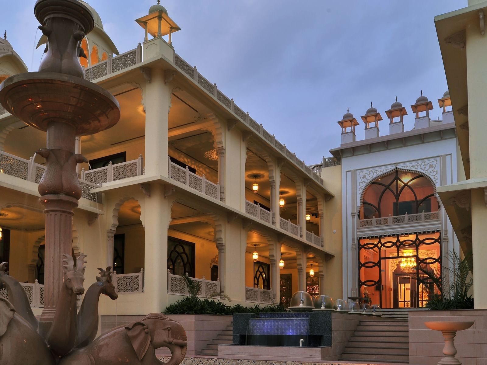 Facade of Rajasthali Resort & Spa Jaipur with lights glowing from the inside.