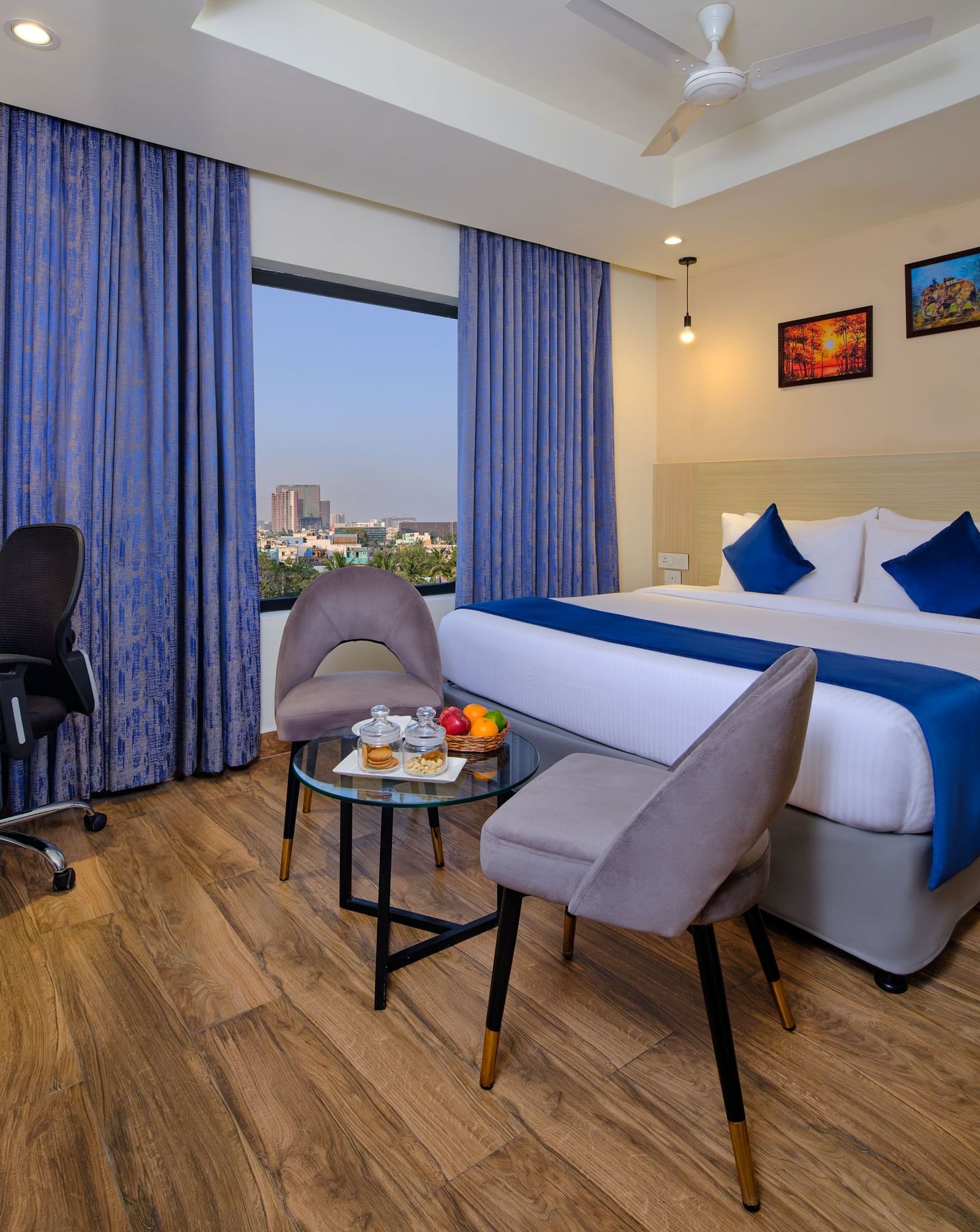 A room at Essentia Premier Hotel, Chennai with a double bed, a television and a work desk and chair