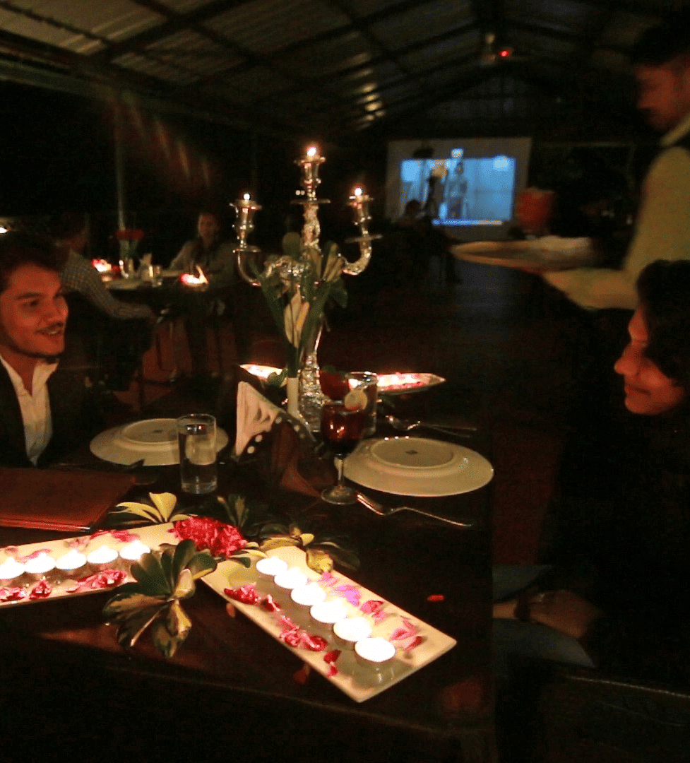 Image of a two people dining with tea light candles placed on the table at Coorg Jungle Camp Backwater Resort, Kushalnagar.