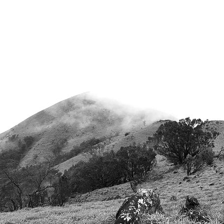 Black and white photo of misty mountains.