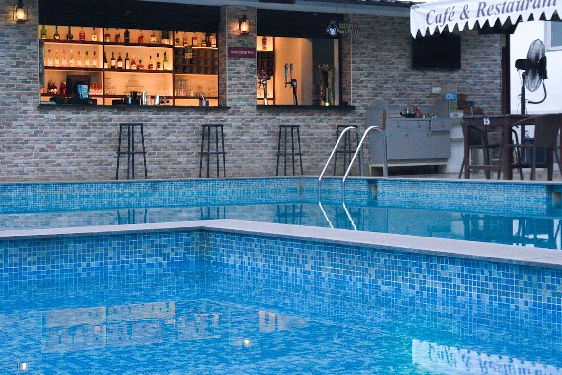Twilight view of pool and bar at Vistar Resort. | Vistar Resort, Bengaluru