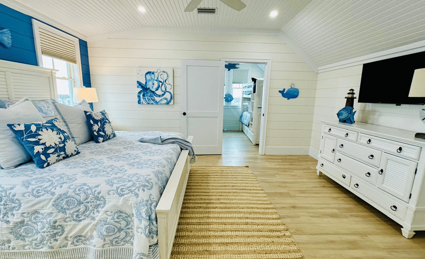A view of a bedroom at Elbow Room Villa 7 in  Abaco inn with a double bed, a TV mounted to the wall and wooden floor