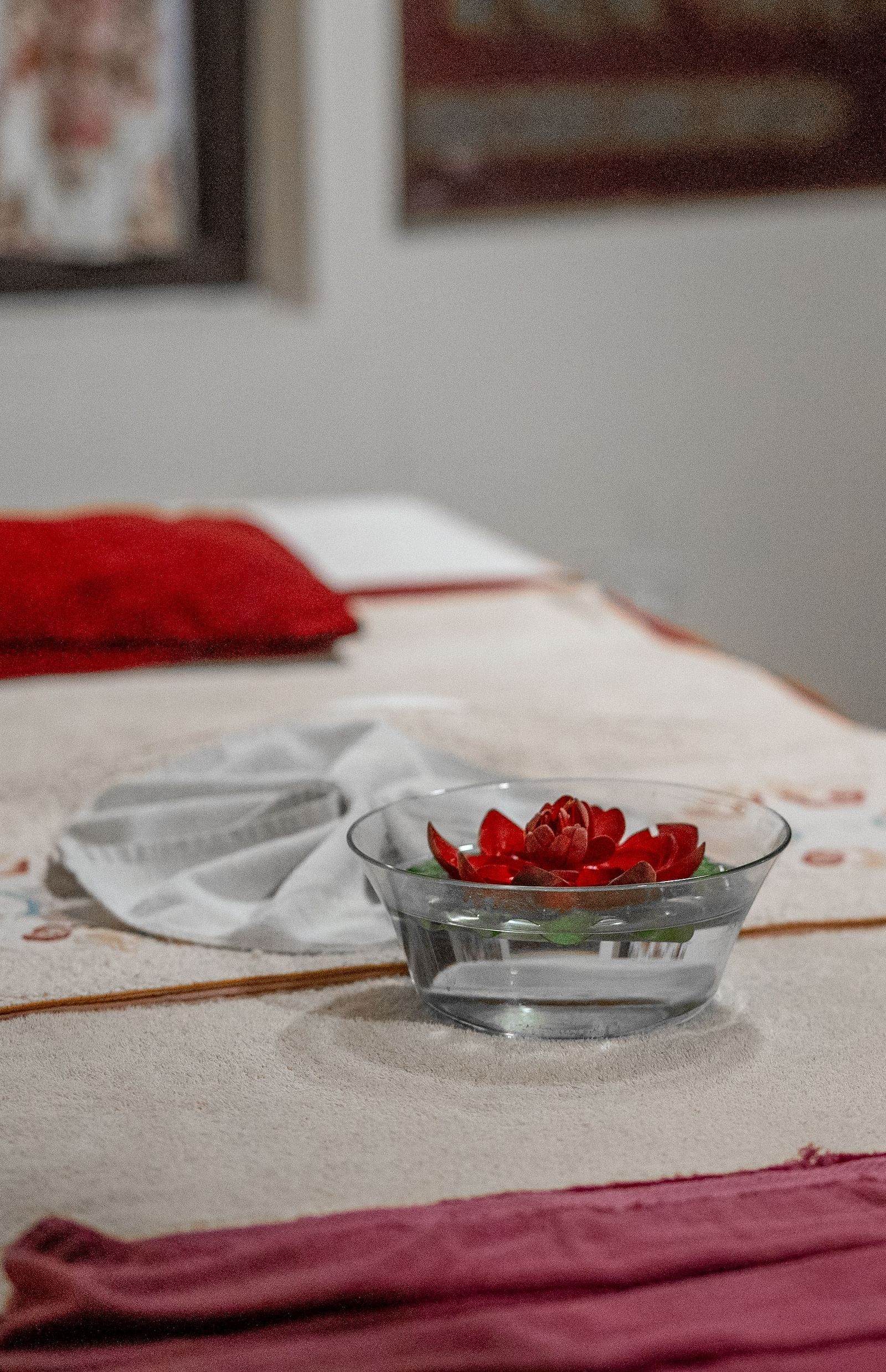 The spa area is meticulously arranged with cushions, plush sheets, neatly folded towels, and a glass bowl filled with water and flowers at Summit Norling Resort & Spa, Gangtok