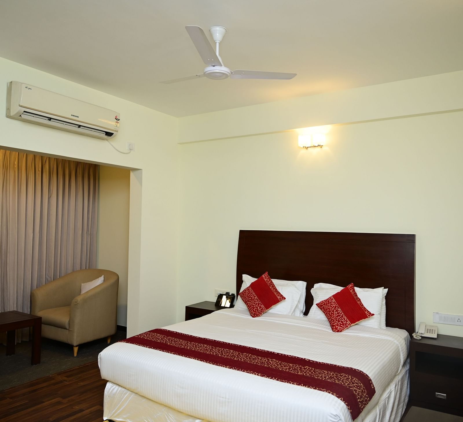 A double bed with red blanket and red pillow covers in the Executive Suite at Sterling Keys by TGI 1