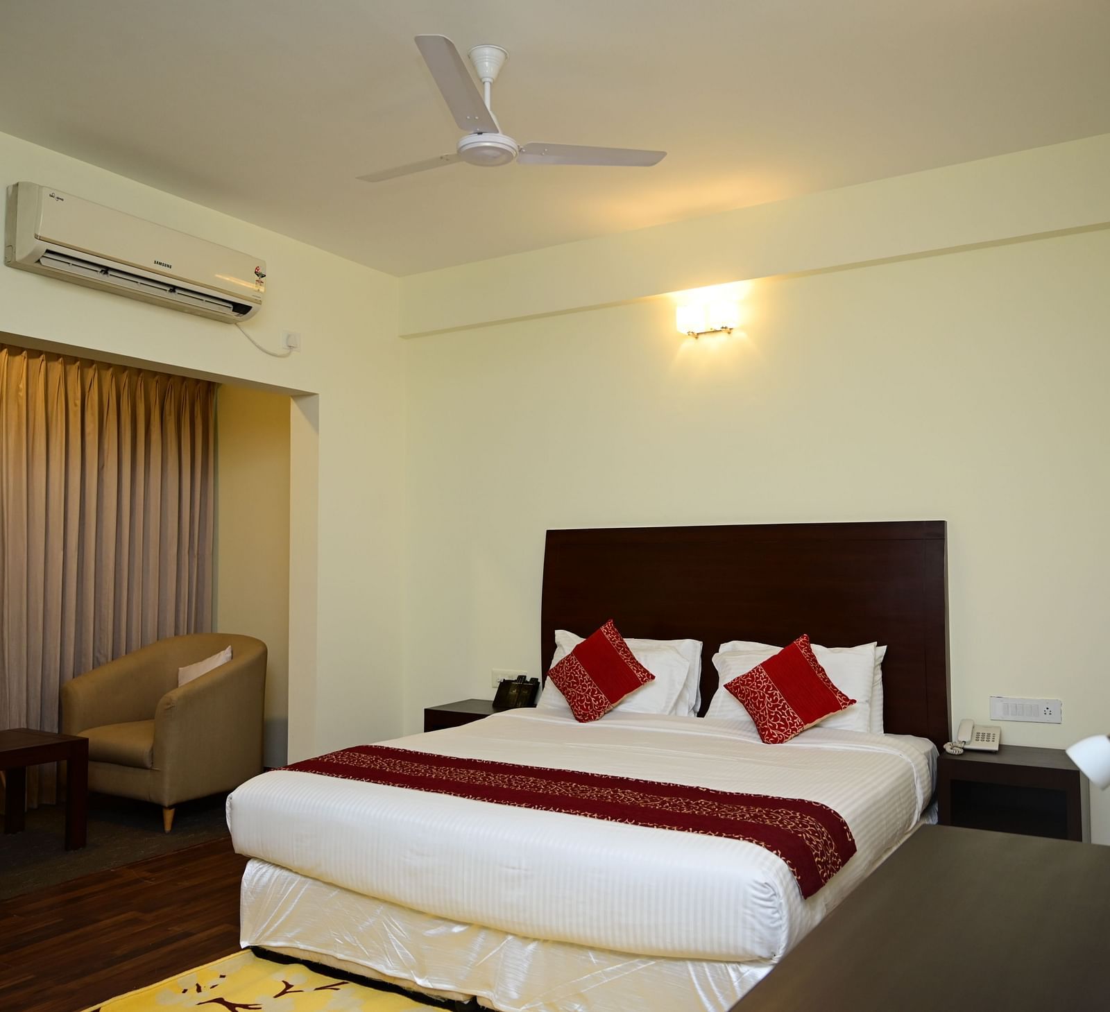 A double bed with red blanket and red pillow covers in the Executive Suite at Sterling Keys by TGI 4
