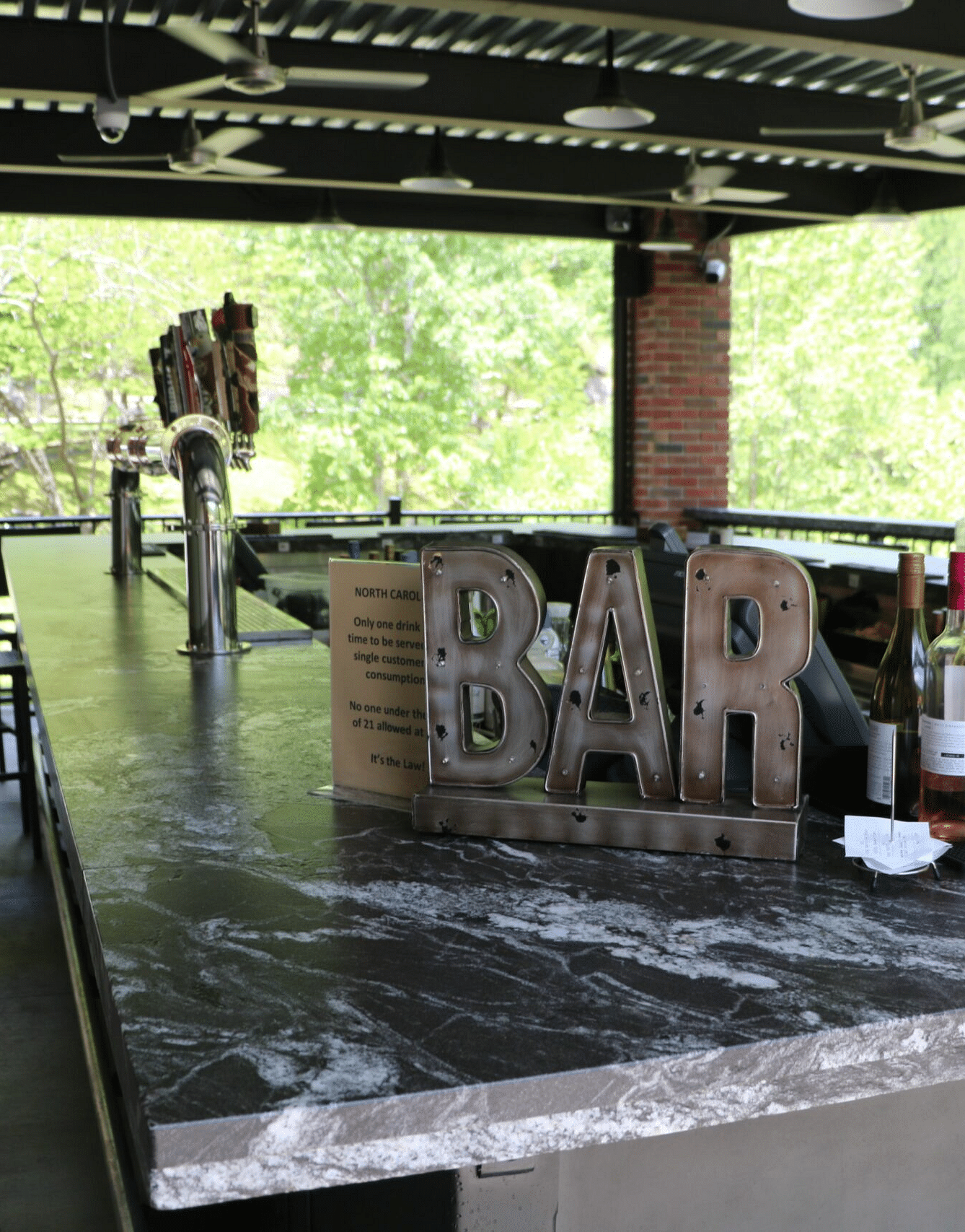 an open bar with a variety of alcoholic bottles on display kept on the counter - Historic Tapoco Lodge
