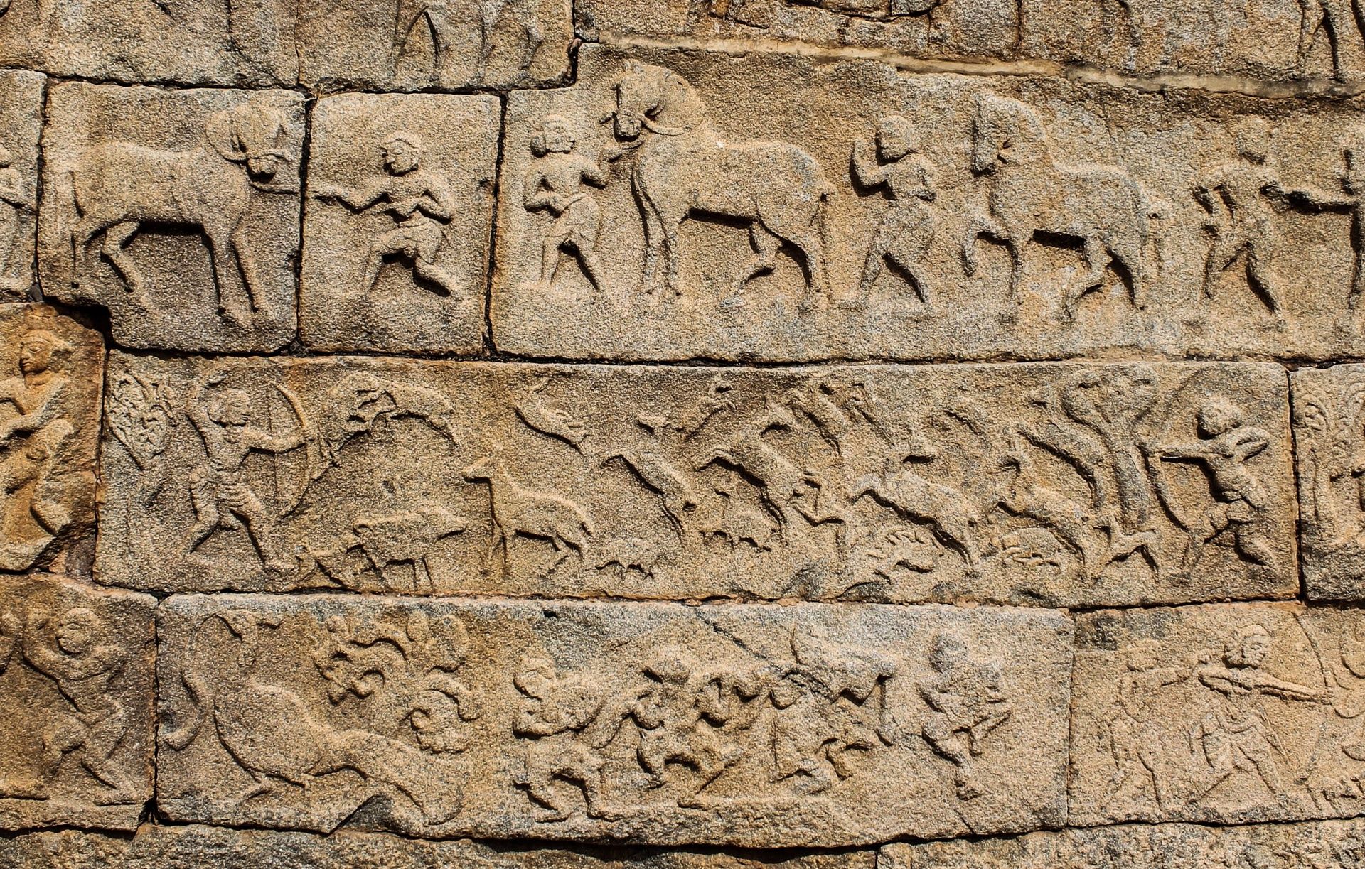 Detailed Hampi stone carvings of daily life scenes.