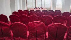 Interior of a hall with neatly arranged chairs and a table in the center