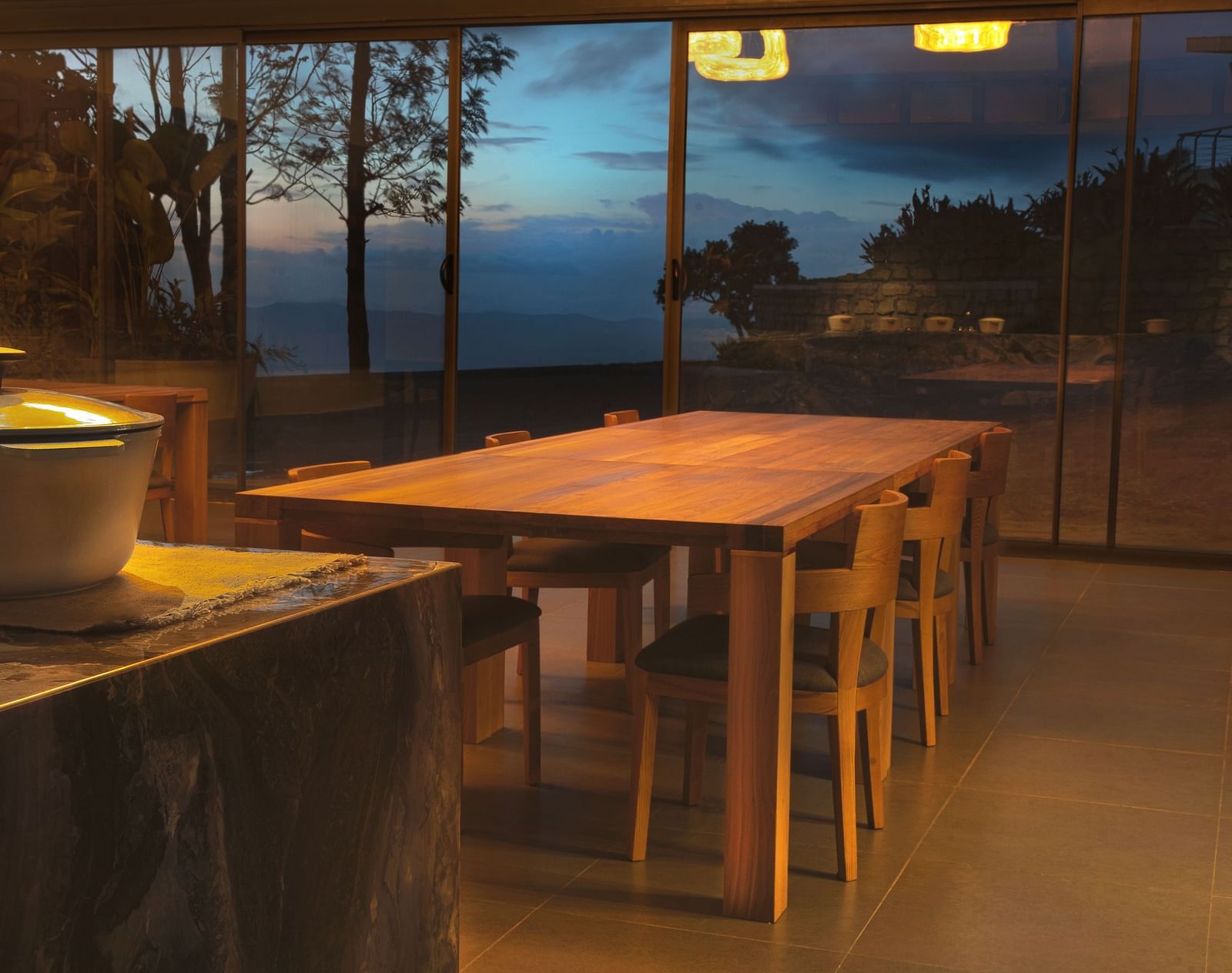 A dining area with wooden tables and chairs with a food container on the side at Stanley Revelation.