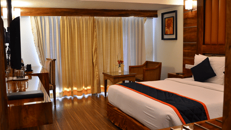 A premium room featuring balcony access, cosy lighting, and wooden flooring for a classy ambience - Benzz Park, Kodaikanal