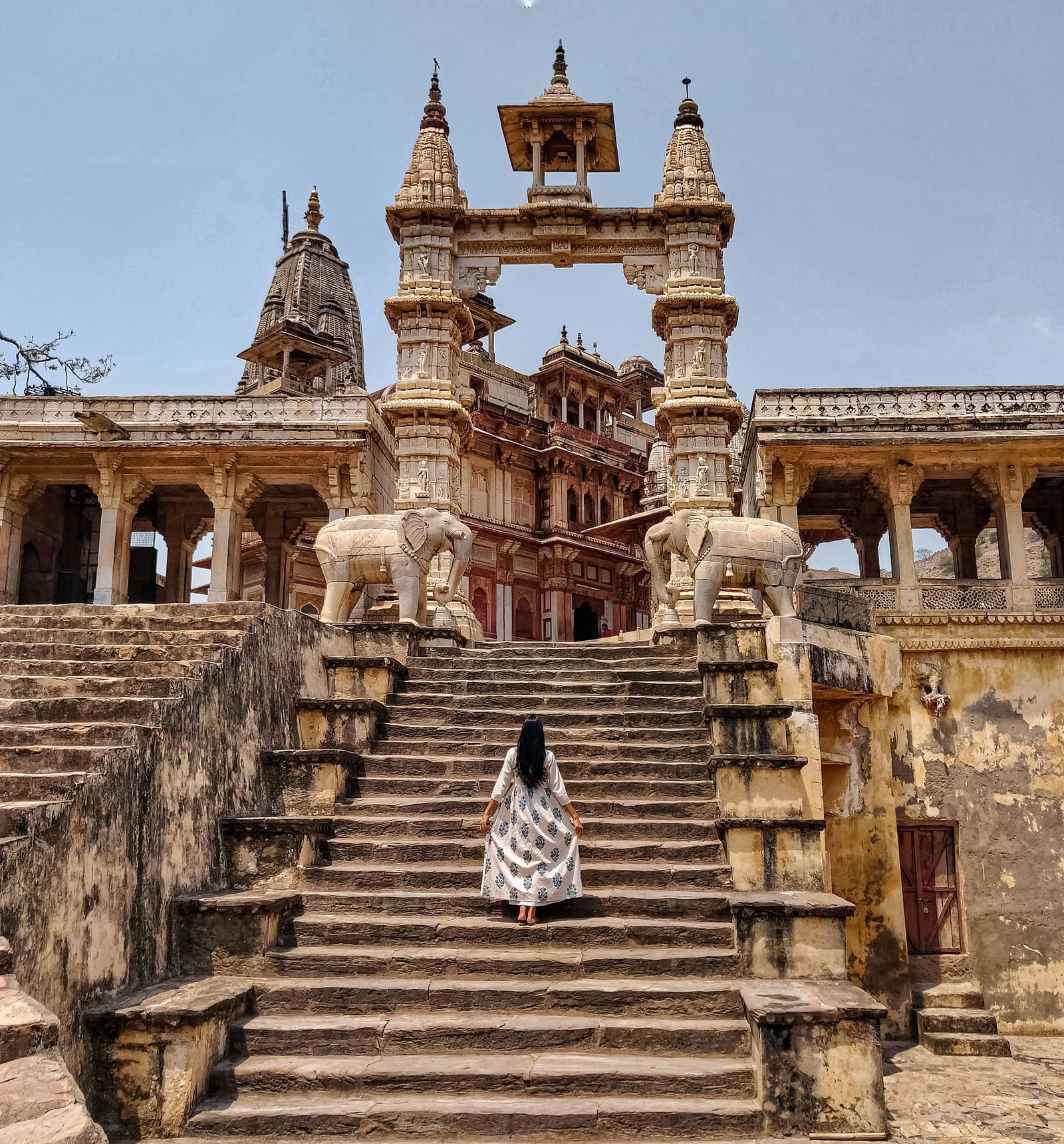 A stone temple with intricate carvings and a staircase leading up to it.