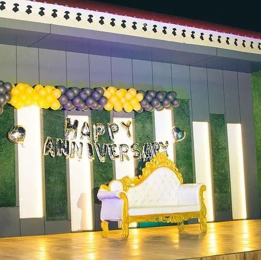 A well-lit stage setup with colourful backdrops for an event at Daksh Resort and Amusement Park.