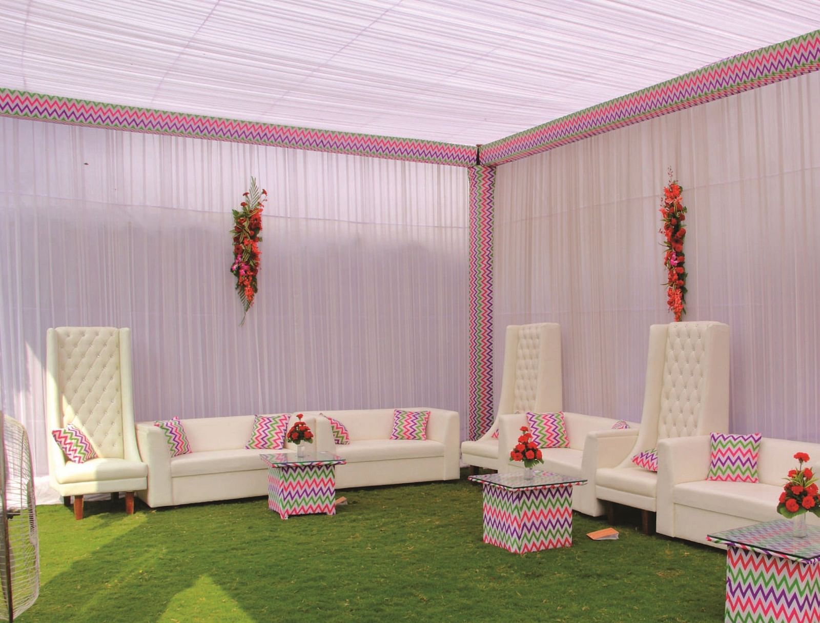 Side-angle view of a seating area with white sofas and pink canopy for an event | Gemini Continental