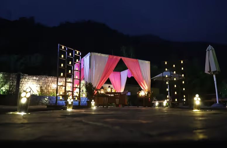 An image showing a beautiful cloth decoration, with the mountain ranges in the backdrop, held together for an eventful night - The Naini Retreat, Nainital