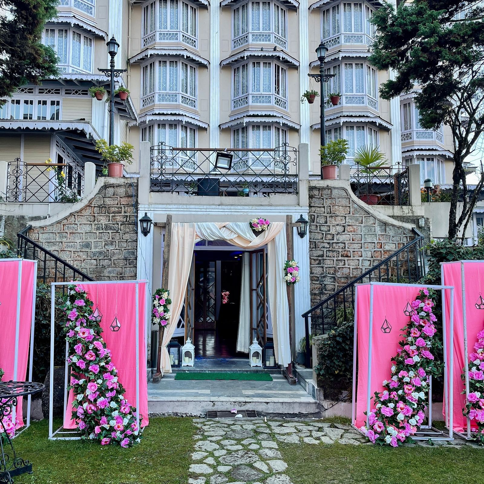 Wedding entrance decor at Cedar Inn, Darjeeling, showcasing the lawn area with floral arrangements and the property's charming exterior.