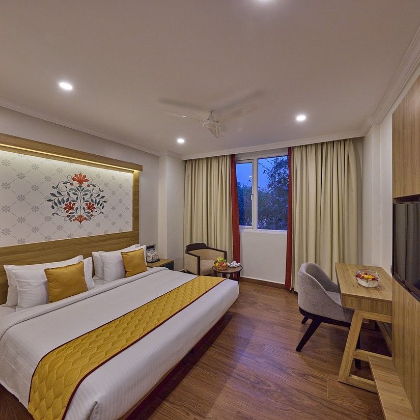 view of a king size bed facing the TV offered at the suite - Golden Tulip, Tirupati