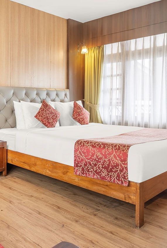 Image of a room with bed and large windows at Summit Tashi Ghang Heritage Resort, Pelling