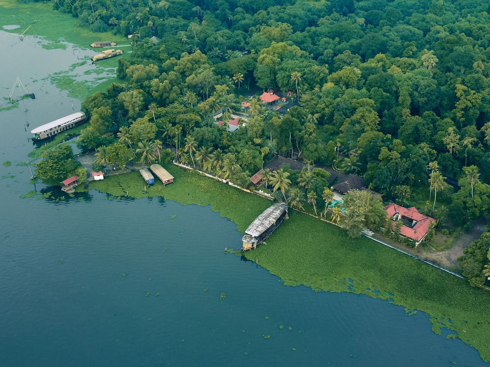 An aerial shot showcasing the Vembanad Lake and the resort surrounded by lush greenery - BluSalzz Villas - Muhamma Resort, Alleppey