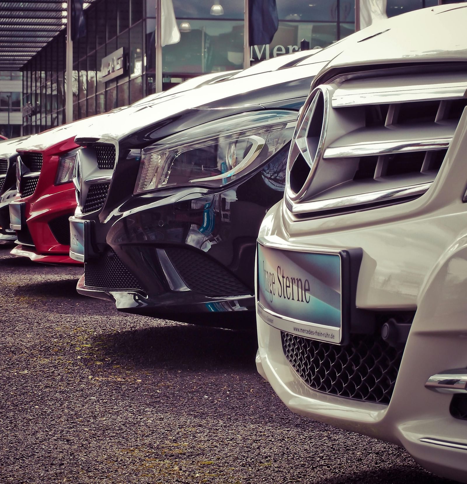 an image of A spacious parking lot filled with neatly parked cars of various colours and models, organised in straight rows.