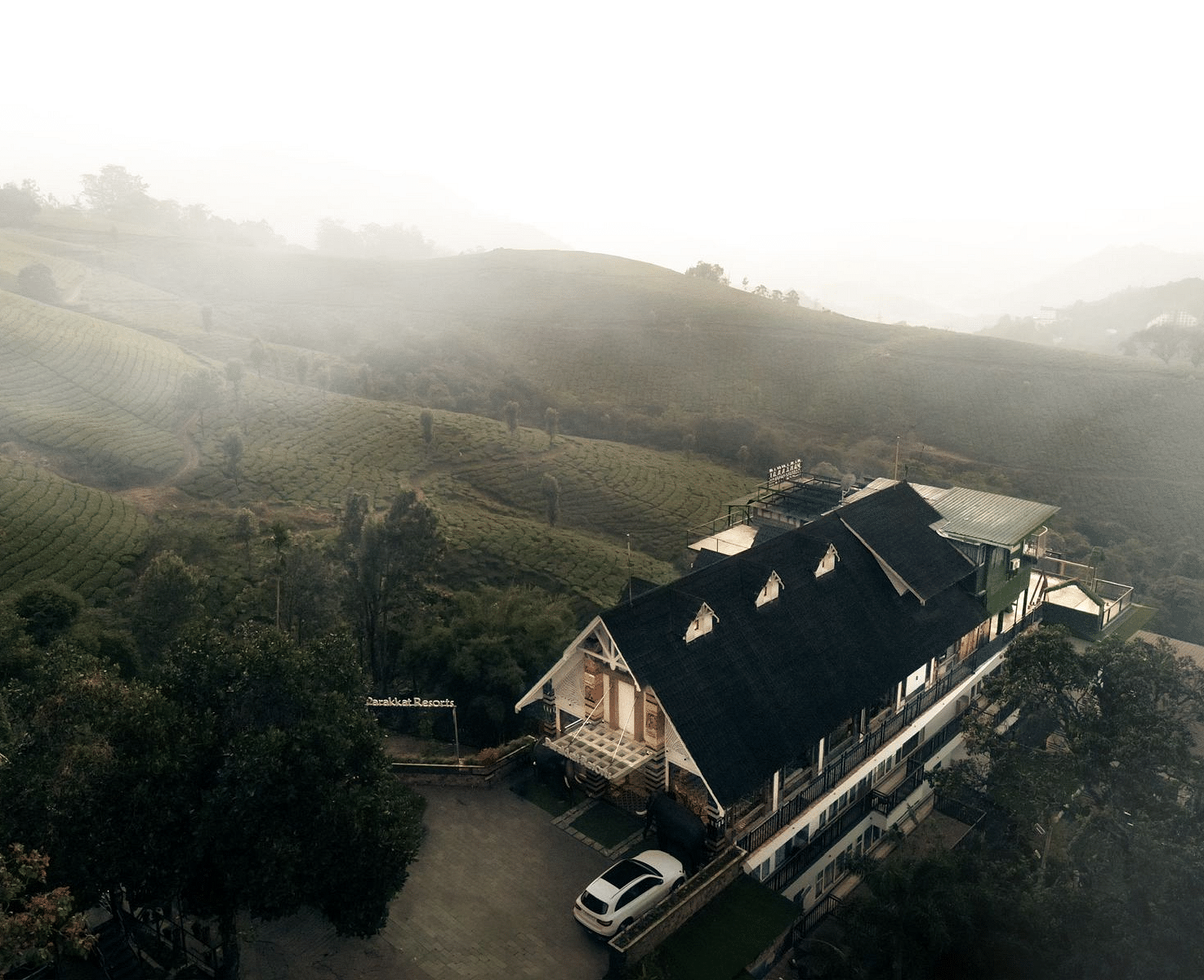Drone view of the Facade of Parakkat Nature Hotel and Resorts, Munnar surrounded by greenery