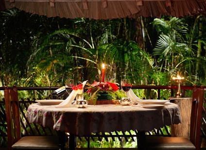 Romantic private dining setup on a balcony surrounded by lush tropical foliage - BluSalzz Collection - Tranquil Resort, Wayanad