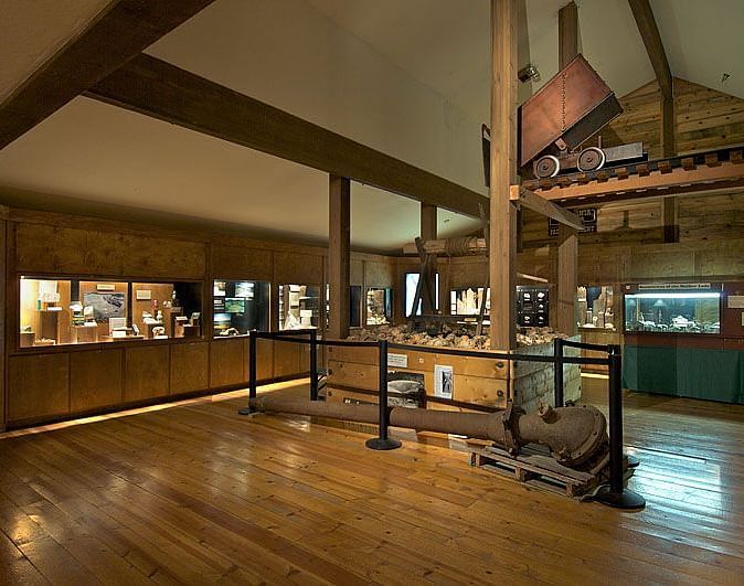 Interiors of a museum with wooden theme and a construction equipment placed in the middle.