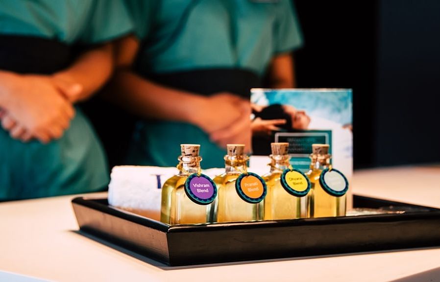 This image showcases a spa setting. A tray holds several small bottles of essential oils.