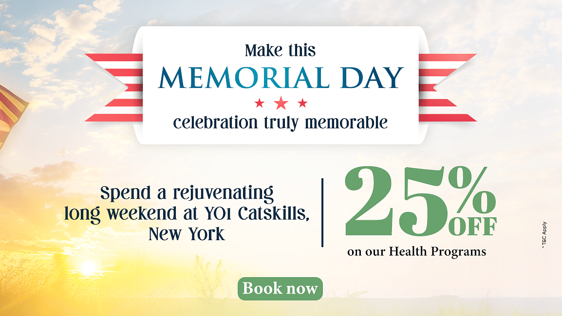 A soldier standing in front of the US flag as the sun is rising from the horizon as the text says - Make this Memorial Day celebration truly memorable. 25% off on our health programs at YO1 Longevity & Health Resorts