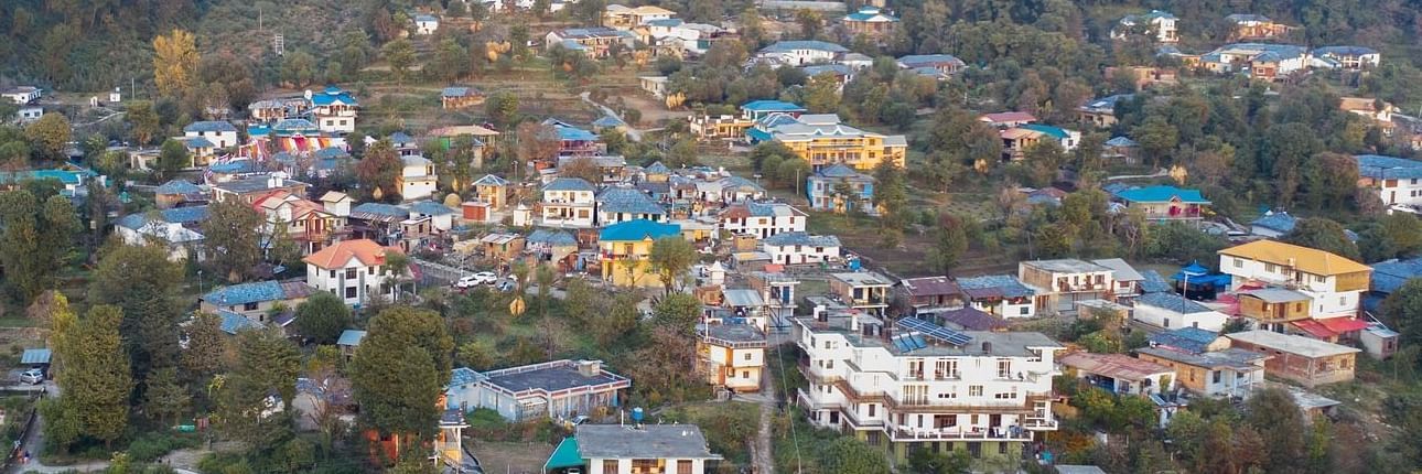 A birds eye view of a small town at the lap of a hill on all sides