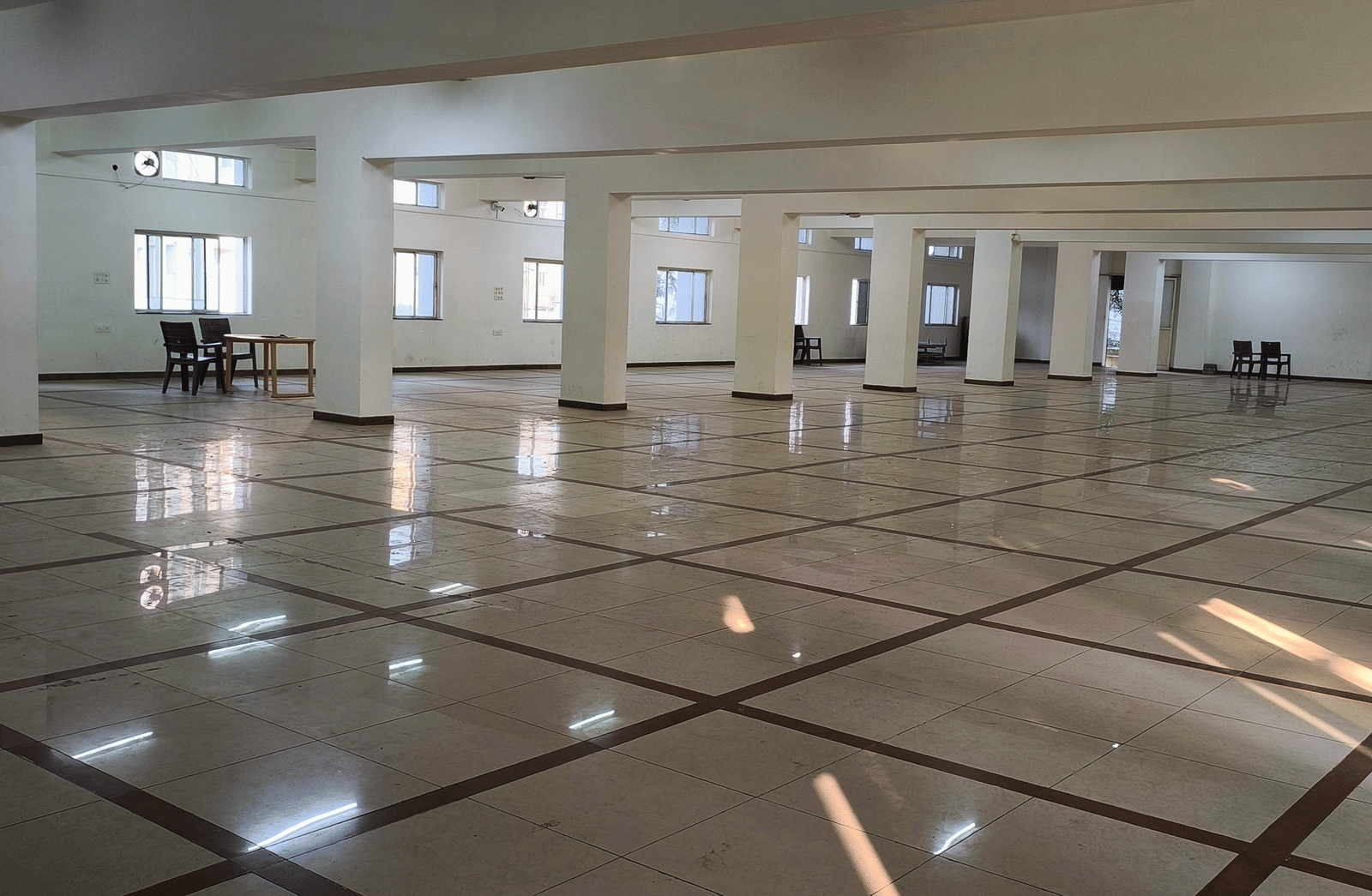 A view down a long, empty banquet hall at BNGV Grandeur Hotel and Banquets, illustrating the hall's capacity and elegant flooring.