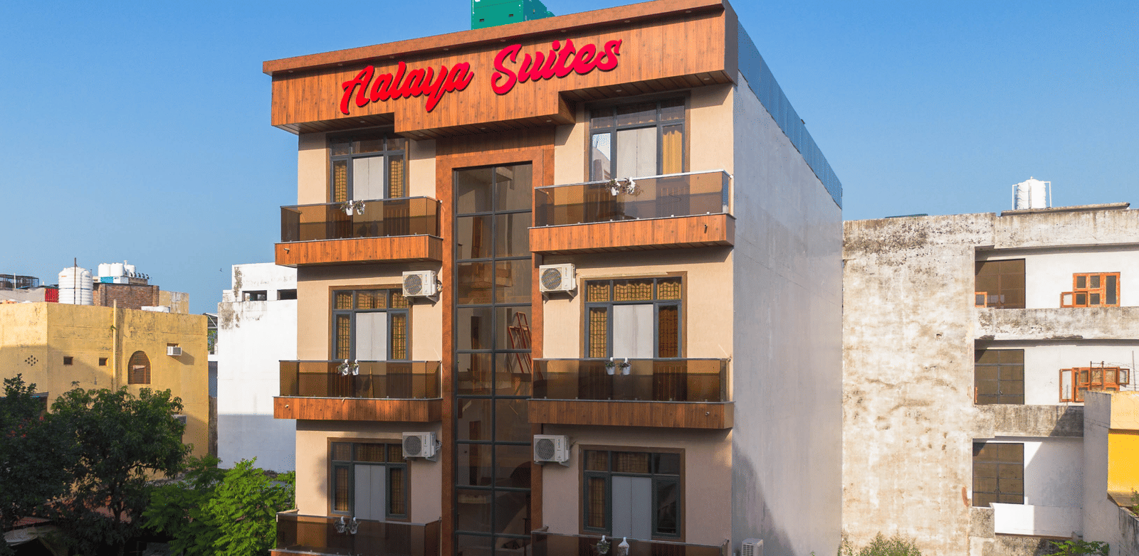 Exterior view of the multi-storey hotel building with 'Aalaya Suites' written on top under a bright blue sky - Perfectstayz Value Aalaya Suites, Haridwar