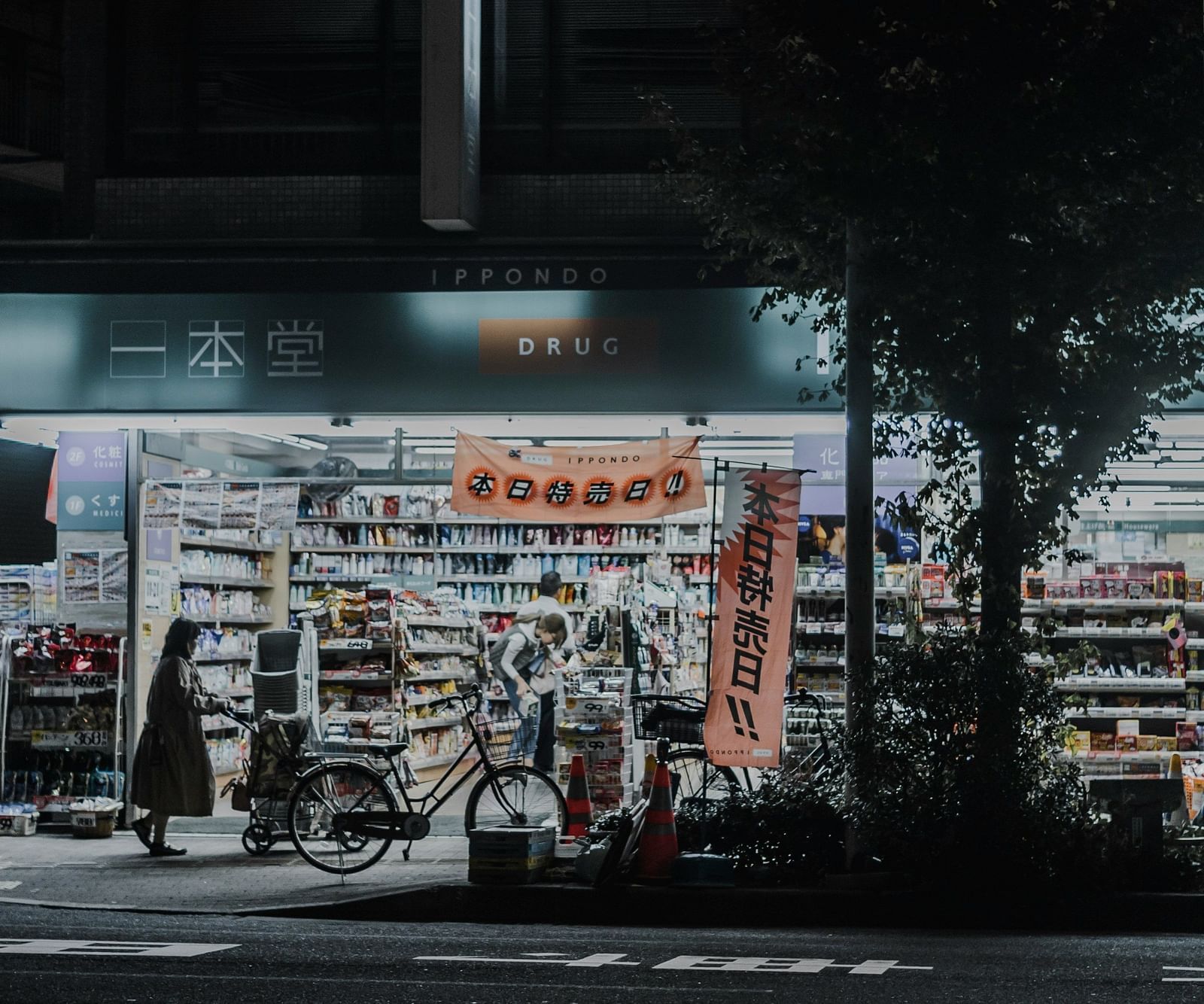 A far out view of a street shop with a person shopping in the night
