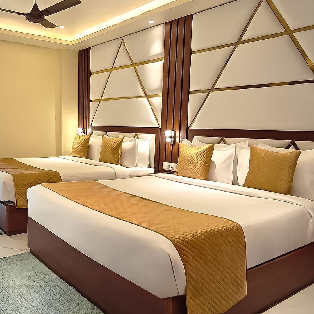 Family Suite featuring two king size beds and a large window covered with curtains at Yashshree Bangla Queen, Digha.