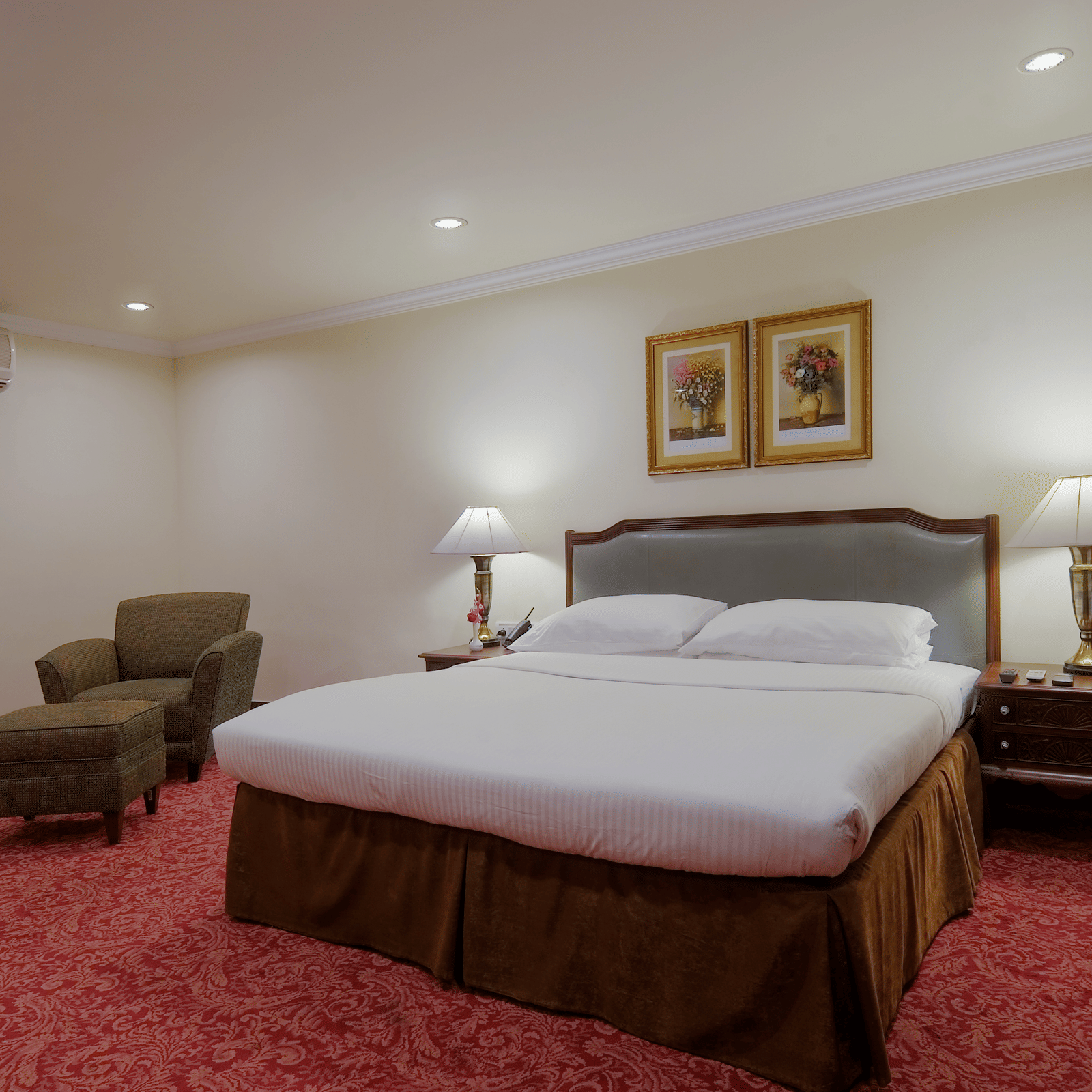 a king size bed and a seating space - Mayfair Garden Rourkela