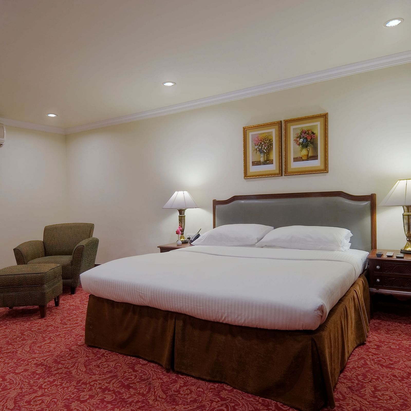 a king size bed and a seating space - Mayfair Rourkela